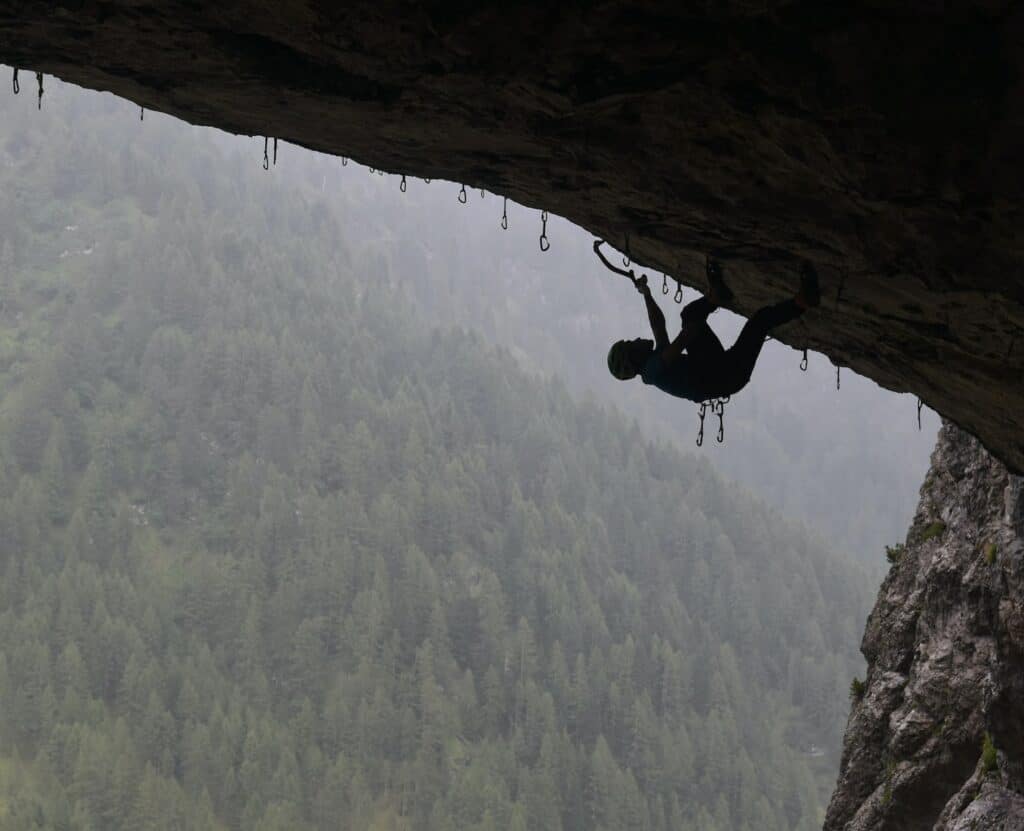 man in black jacket climbing mountain during daytime