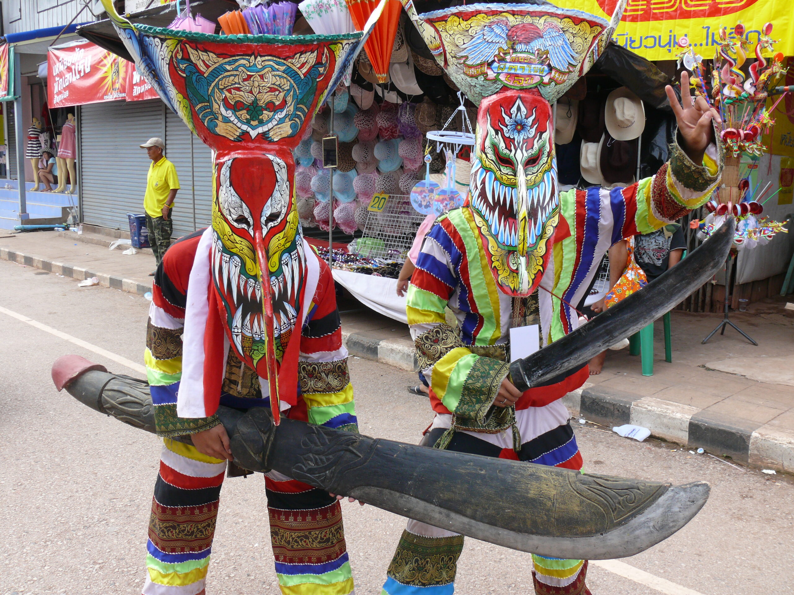 Collection of Phi Ta Khon ghost masks on display showing the traditional sticky rice basket and coconut palm construction