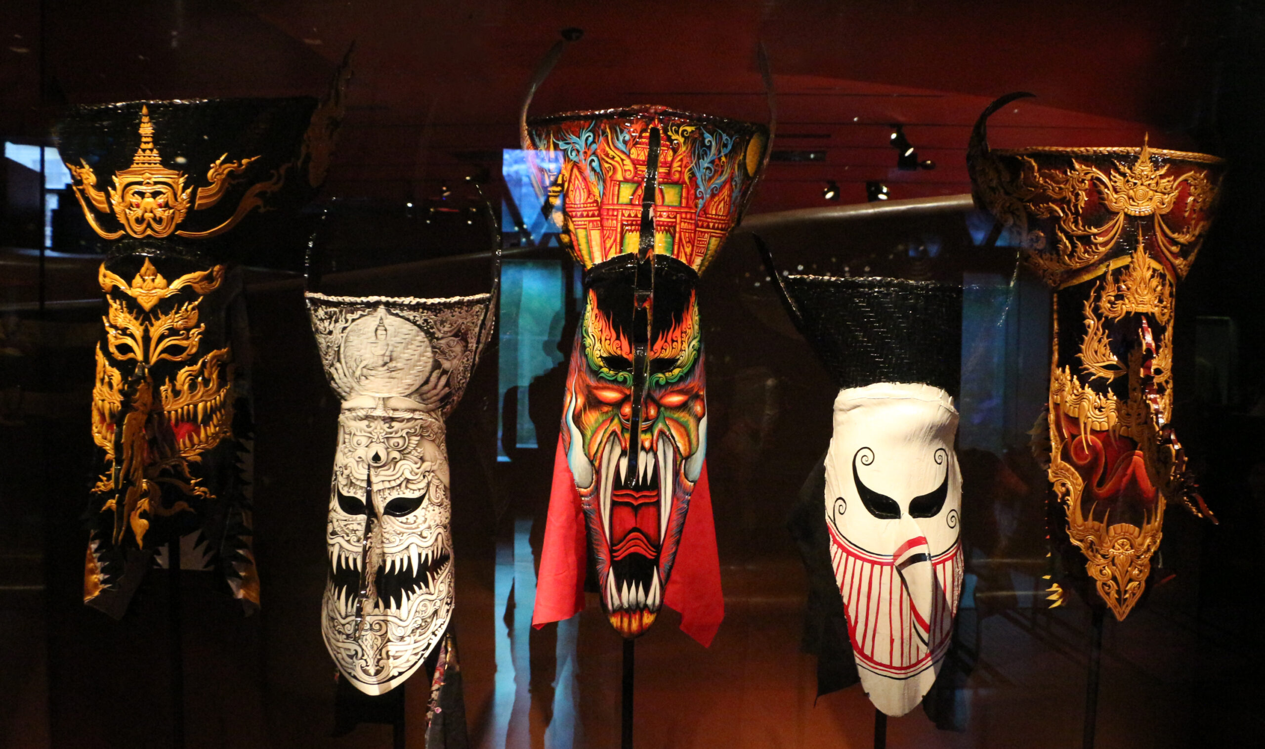 Phi Ta Khon masks in a museum display showing the artistic variety of ghost mask designs