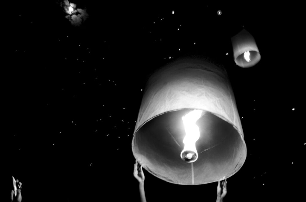 Thousands of sky lanterns rising into the night sky during Yi Peng festival in Chiang Mai, Thailand