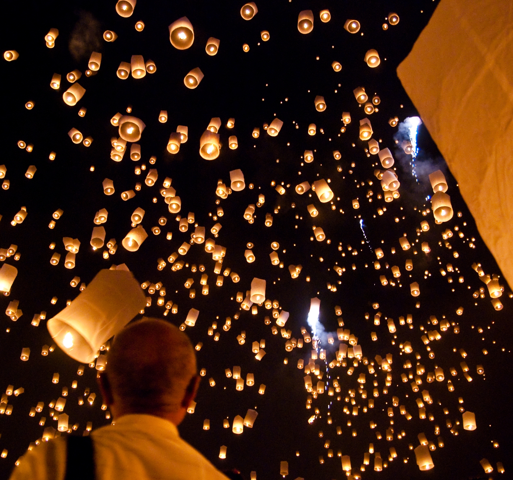Sky lanterns floating above a crowd at the Yi Peng sky lantern festival in San Sai, Chiang Mai
